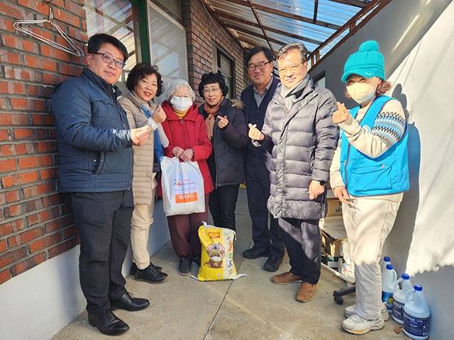 삼문동 주민자치회, 체육회, 자원봉사회가 선물꾸러미를 전달 후 기념사진을 찍고 있다.