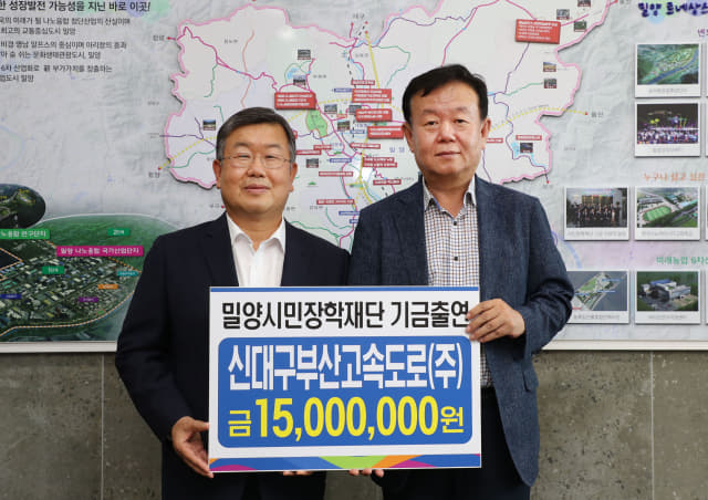 이상만 신대구부산고속도로(주) 대표이사가 박일호 (재)밀양시민장학재단 이사장에게 장학금을 전달하고 있다.