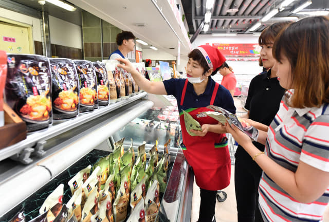 중복을 하루 앞둔 21일 김해시 농협김해유통센터에서 고객들이 ‘녹두삼계탕’, ‘누룽지 오곡 삼계탕’ 등 다양한 간편식 삼계탕 제품을 살펴보고 있다./전강용 기자/
