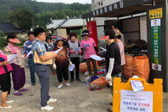 6일, 도천면 예리2구 마을 주민들이 재활용동네마당 앞에서 생활쓰레기 분리 배출 요령에 대한 설명을 듣고 있다.