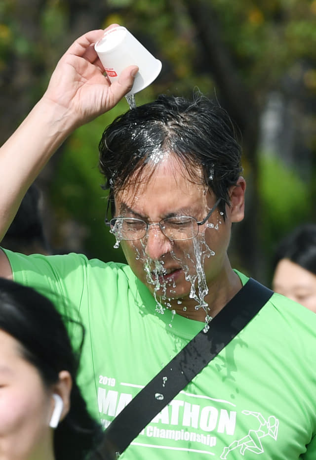 10㎞ 한 참가자가 창원교육단지 급수대에서 얼굴에 물을 뿌리고 있다.