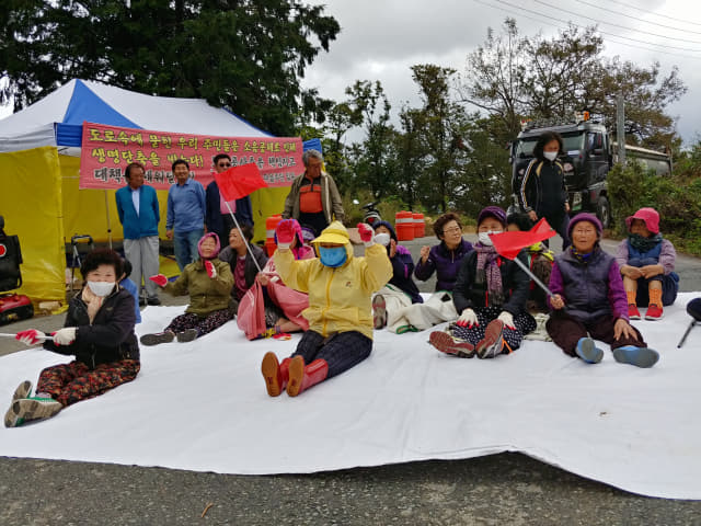 15일 오전 김해시 대동면 신암마을 주민들이 국지도 69호선 공사 현장 입구에서 피해 대책 마련을 촉구하는 집회를 열고 있다.