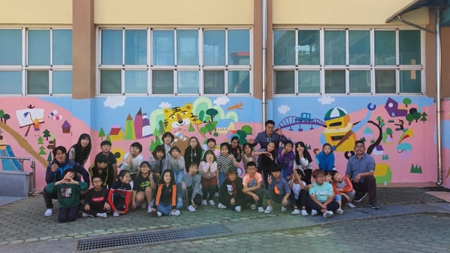 함안 칠서초등학교가 추진한 도나온 벽화 그리기 프로젝트에 참여한 학생과 교직원 모습./함안교육지원청/