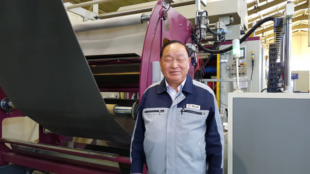 우재홍 ㈜무진 대표가 지난달 31일 양산시 산막공단 내 공장 자동차 시트 소재 제조장비 앞에서 포즈를 취하고 있다.