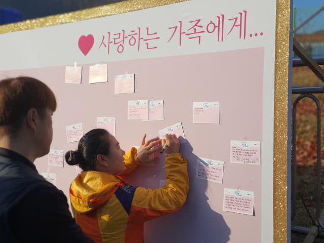 걷기대회에 참가한 임직원과 가족들이 가족들에게 바라는 점을 엽서에 써서 남기고 있다. /삼성중공업/