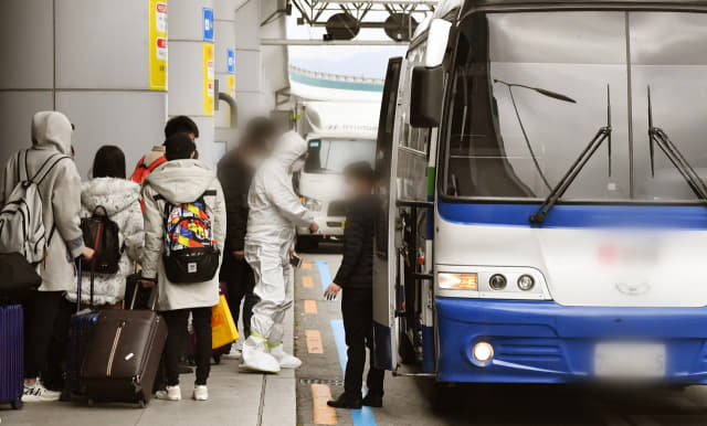 26일 김해공항 국제선 청사 입구에서 방진복을 입은 관계자의 안내에 따라 중국인 유학생들이 차량에 짐을 싣고 있다./전강용 기자/