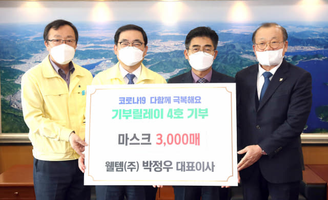 웰템(주) 박정우(오른쪽 두번째) 대표이사가 5일 창원시에 마스크 3000매를 기부한 뒤 허성무 창원시장 등과 기념촬영을 하고 있다./전강용 기자/