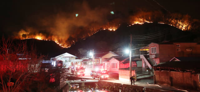 19일 오후 울산시 울주군에서 발생한 산불이 바람을 타고 번지면서 청량읍 삼정마을 인근 야산에까지 불길이 치솟고 있다. 연합뉴스