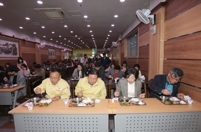 함안군청 구내식당에서 조근제 군수와 직원들이 한 방향을 보고 식사하고 있는 모습(왼쪽)과 의령군청 구내식당에 설치된 투명 칸막이 모습./함안군·의령군/