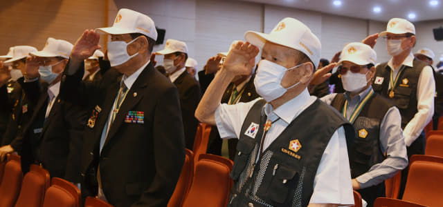 25일 오후 경남도청 신관 대강당에서 열린 6·25 전쟁 제70주년 행사에서 참전 용사들이 국기에 대한 경례를 하고 있다./김승권 기자/