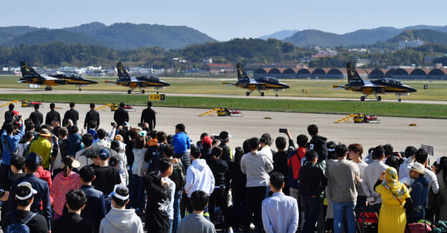 ‘2019 사천에어쇼’에서 관람객들이 공군 블랙이글스 특수비행팀의 T-50B 비행기가 활주로로 이동하는 장면을 보고 있다./경남신문DB/