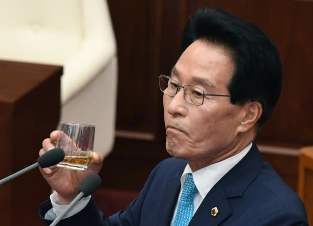 김하용 경남도의회 의장이 의장 불신임의 건 상정에 대한 반대 의견 설명 중 물을 마시고 있다.