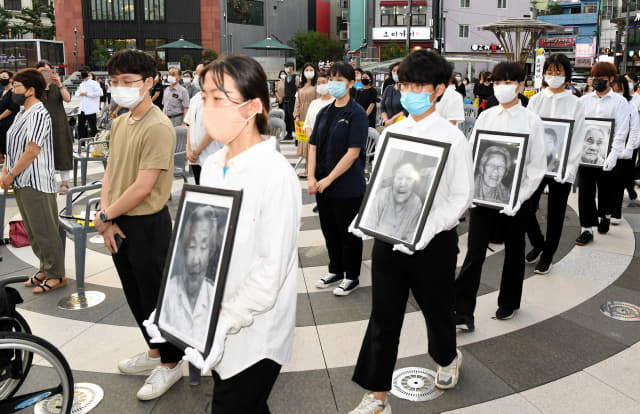 12일 오후 창원시 마산합포구 오동동 문화광장에서 열린 ‘2020 일본군 위안부 피해자 추모문화제’에서 참석자들이 위안부 피해자 할머니들의 영정사진을 들고 입장하고 있다./성승건 기자/