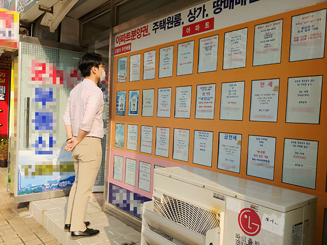 20일 오후 창원의 한 공인중개사 사무실 앞에서 시민이 매물 안내판을 살펴보고 있다.
