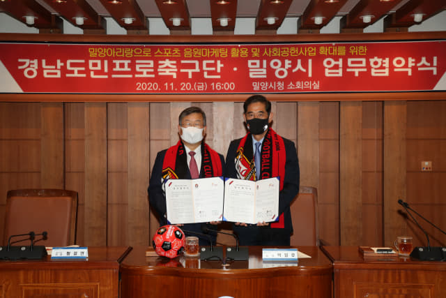 박일호 밀양시장(왼쪽)과 경남FC 박진관대표가 밀양아리랑을 경남FC응원가로 제작하기위한 협약을 하고 있다./경남FC