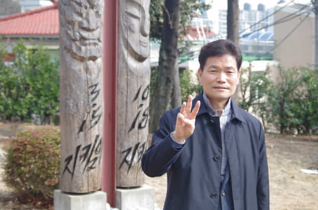 정성기 교수가 부마민주항쟁 마산지역 발원지인 경남대에 설치된 3·15, 10·18 기념 정승 앞에서 미얀마 군부 독재에 대한 저항을 상징하는 세 손가락 경례를 하고 있다.