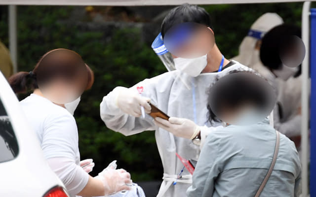 김해시의 한 선별진료소에서 시민들이 코로나19 검사 접수를 하고 있다./경남신문 자료사진/
