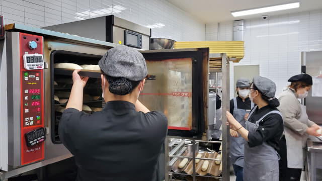 24일 창원시 마산회원구에 있는 청년 자립 지원 프로젝트 베이커리 카페 ‘빵그레 1호점’에서 제빵 담당 직원들이 빵을 구워내고 있다.
