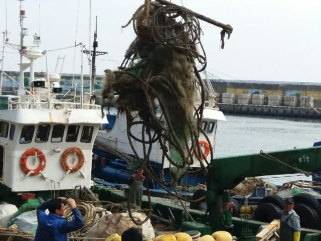 통영항에 정박한 한 어선이 조업 중 건져 올린 바다쓰레기를 처리하고 있다./경남신문DB/