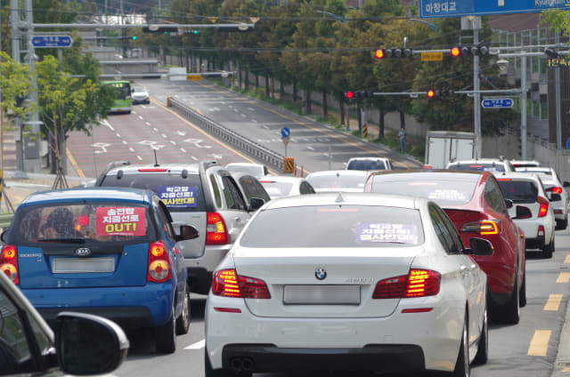 21일 오후 3시 월영마린애시앙 후문 앞 도로에서 '송전탑 지중선로 반대' 등의 피켓을 부착한 차량 50여대가 차량 시위를 벌이고 있다.