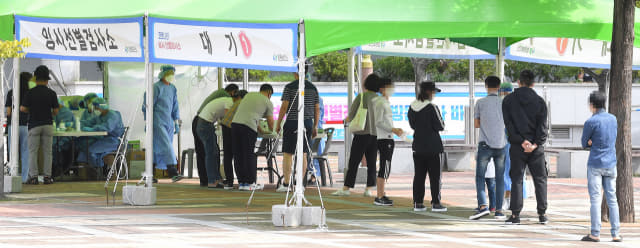 26일 창원종합버스터미널 앞 임시선별검사소에서 시민들이 코로나19 검사를 받기 위해 기다리고 있다./김승권 기자/