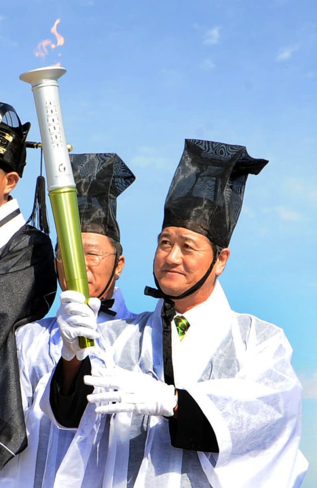 2010년 당시 경남도 성화인수단장이었던 박소둘씨가 인천시 강화군 마니산 참성단에서 채화한 성화를 전달받고 있다.