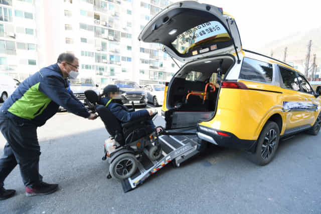 김 대리가 장애인으로부터 호출을 받고 휠체어를 탄 장애인을 교통약자 특별 교통수단에 태우고 있다.