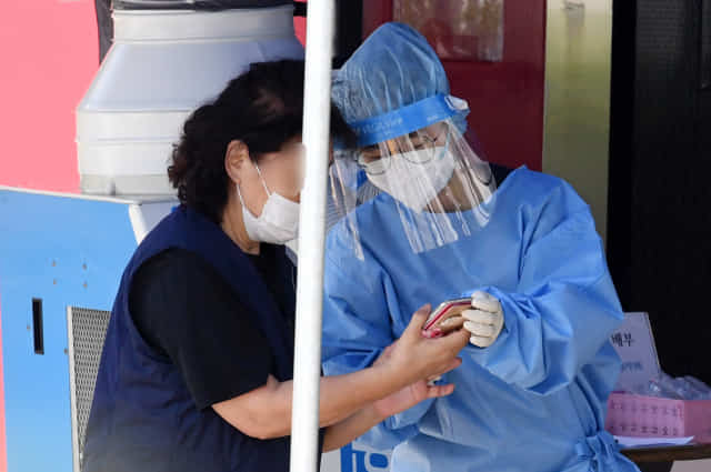 24일 오후 창원시보건소 선별진료소에서 한 의료진이 코로나19 검사를 받으러 온 시민을 안내하고 있다./성승건 기자/