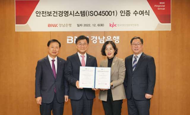 BNK경남은행 최홍영(왼쪽 두 번째) 은행장이 한국생산성본부인증원 오경희(왼쪽 세 번째) 원장으로부터 안전보건경영시스템(ISO45001) 인증서를 전달 받고 있다./경남은행/