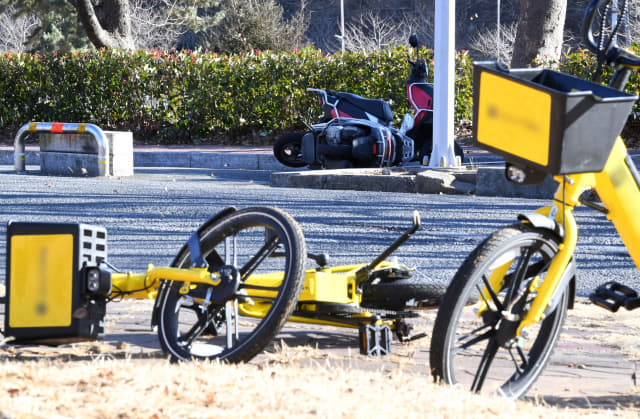 24일 오후 창원대학교 정문 인근에 공유자전거와 오토바이가 강한 바람에 쓰러져 있다./성승건 기자/