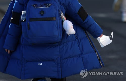 (부산=연합뉴스) 손형주 기자 = 1월 25일 부산 남구 한 초등학교에서 한 학생이 마스크를 손에 쥐고 하교하고 있다. 2023.1.25 handbrother@yna.co.kr