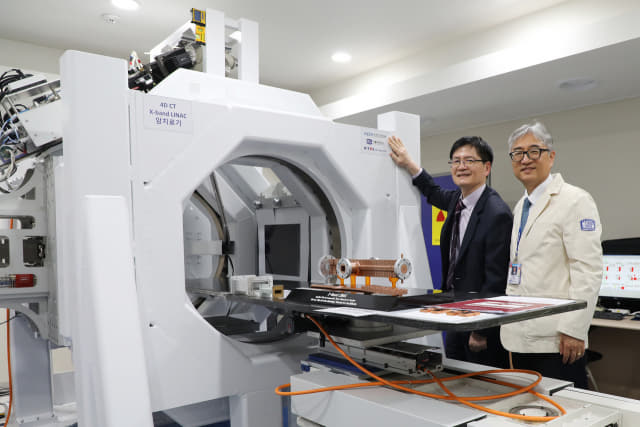 지난 23일 가톨릭대에서 김남균(왼쪽) 한국전기연구원장, 조석구 가톨릭대 의생명산업연구원장이 방사선 치료기술 협력을 위한 협약을 체결하고 ‘X-band 선형가속기 기반 방사선 암 치료기’ 옆에서 기념사진을 찍고 있다./전기연/