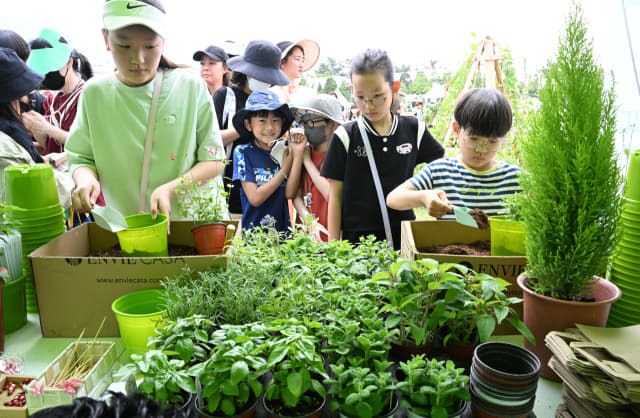 제15회 창원그린엑스포 행사장에서 어린이들이 허브정원 화분 만들기 체험을 하고 있다.