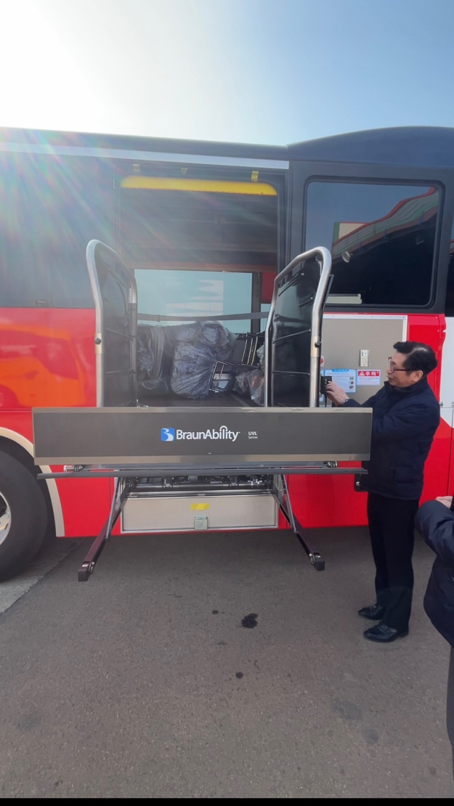 장애인 전용 관광버스의 휠체어 리프트가 작동되고 있다./서진항공여행사/