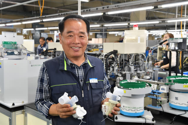 이장수 한국중천전화산업 대표이사가 지난 10일 마산자유무역지역 내 공장에서 생산된 세탁기 배수밸브 부품을 들어보이고 있다. /전강용 기자/