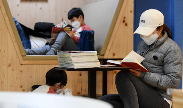 휴일인 8일 창원시 마산회원구 지혜의 바다 도서관을 찾은 한 가족이 마스크를 착용한 채 독서를 즐기고 있다./성승건 기자/