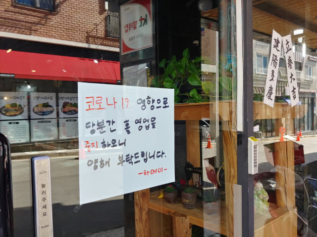 24일 김해시 율하천 카페거리의 한 식당 입구에 코로나19로 휴업한다는 글이 붙어 있다.