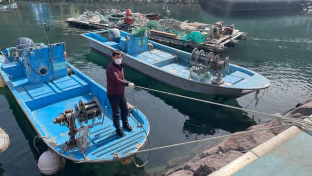 23일 대항어촌마을에서 낚싯배를 운영하는 김영섭씨가 배를 선착장에 고정시키고 있다.
