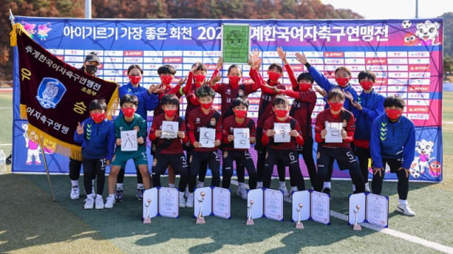 진주 남강초등학교가 2021 추계 한국여자축구연맹전에서 우승한 후 기념촬영을 하고 있다./경남축구협회/