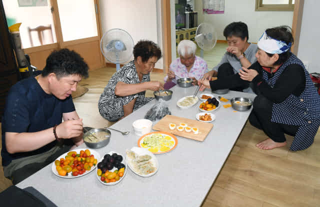 마을 주민들이 경노당에서 취재팀이 만든 냉면, 군만두, 오이무침 등을 먹고 있다.