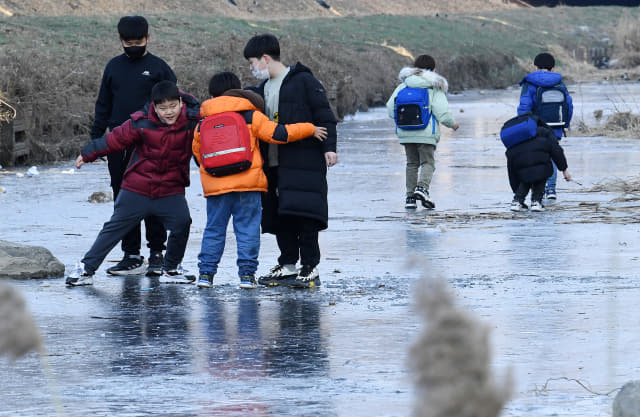 28일 오후 창원시 성산구 창원천에서 아이들이 얼어붙은 하천에서 놀고 있다./성승건 기자/