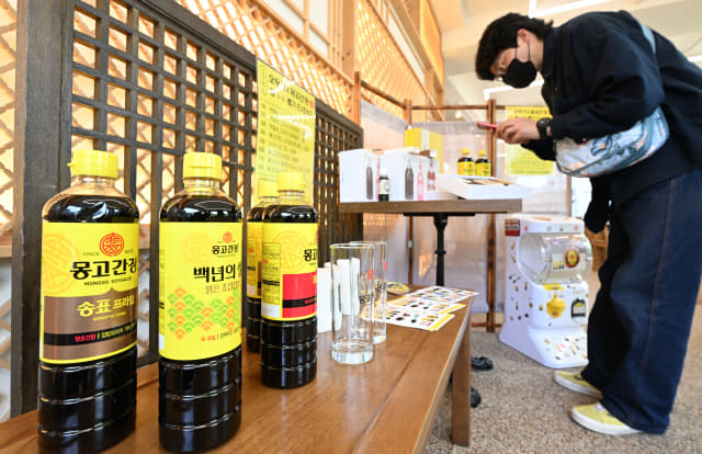 21일 오후 창원시 의창구 베이커리 카페 오우가에서 한 고객이 전시 중인 몽고식품 간장 제품들을 둘러보고 있다./성승건 기자/