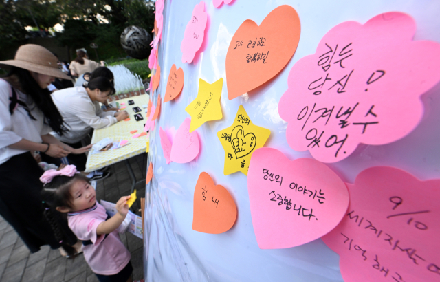 지난 8일 창원시 성산구 용지호수공원에서 열린 ‘세계 자살예방의 날(10일)’ 캠페인에서 시민들이 ‘나에게 그리고 너에게’ 쓴 생명 메시지를 붙이고 있다./김승권 기자/