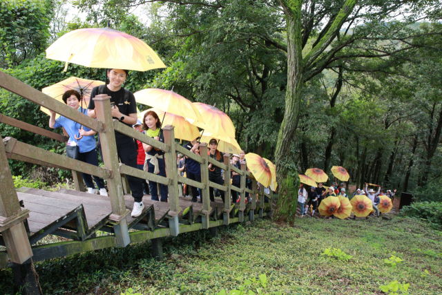 부잣길 걷기행사에서 참석자들이 리치리치페스티벌 상징인 우산을 들고 걷고 있다.