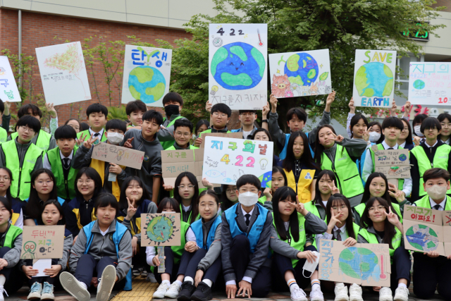구산중 학생들이 지구의 날을 맞아 지구살리기 실천 캠페인을 하고 있다./구산중/